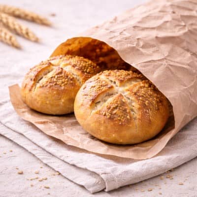 Dinkelvollkornbrötchen in einer Papiertüte mit Leinentuch